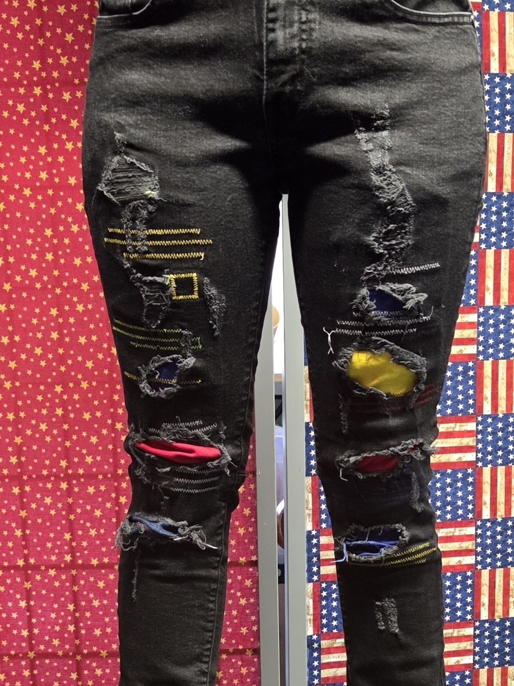 **Black Distressed Men’s Jeans with Color Patch Accents**